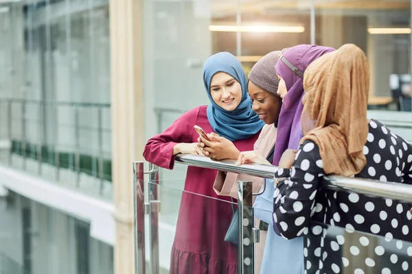 Pareja joven negocio musulmán femenino utilizando el contacto de teléfono inteligente con el socio — Foto de Stock