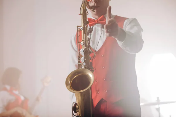 Elegancki facet w garniturze z saksofonem pokazuje kciuki w górę — Zdjęcie stockowe