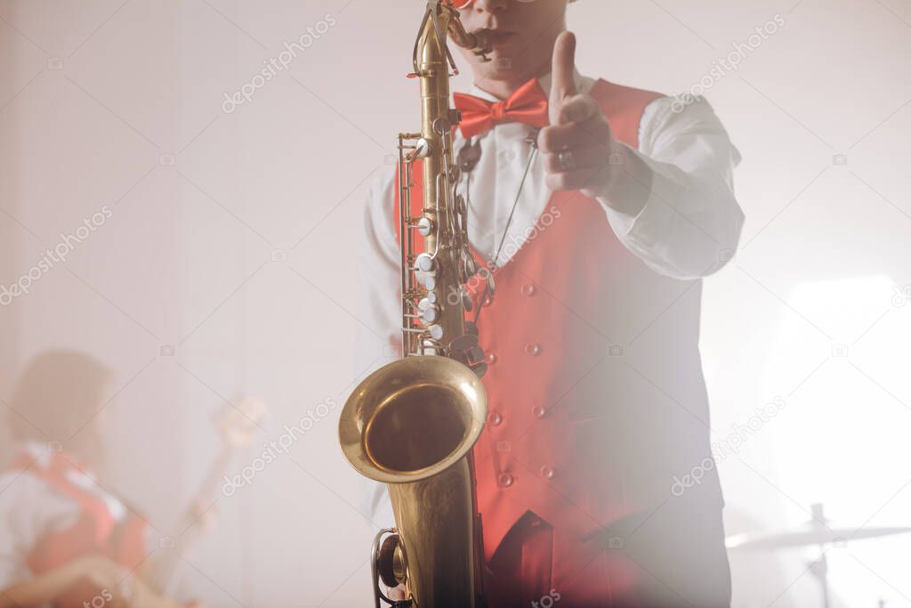 elegant guy in suit with saxophone showing thumbs up