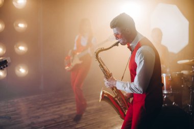 Yan görüş fotoğrafını kapat. Kırmızı takım elbiseli akıllı adam rock 'n roll oynuyor.