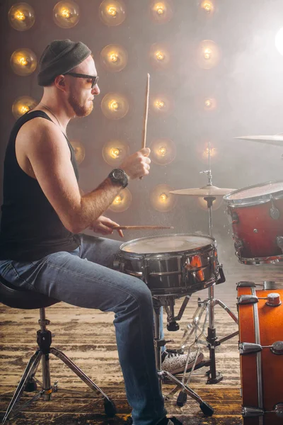 Homem de moda bonito aprendendo a tocar bateria — Fotografia de Stock