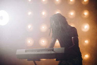 Elektronik müzik aletinin arkasında duran Afrikalı adam