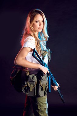 Taktik üniformalı, tüfekli kadın özel askeri müteahhit.