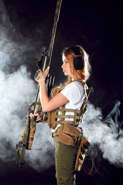 Esercito donna indossa piatto vettore sulla sua vita sottile, tiene fucile snipper in mano — Foto Stock
