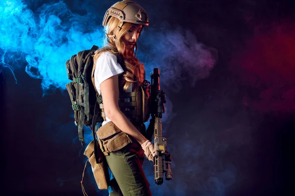 Female soldier in tactical uniform with rifle. Studio shot on smoky background — Stock Photo, Image