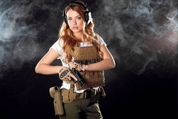 Koruyucu zırhlı kadın elinde silah tutuyor. Ordu, özveri, teknoloji..