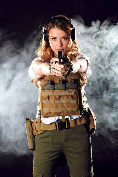 Frau in Schutzrüstung hält Waffe in der Hand. Armee, Engagement, Technologie. — Stockfoto