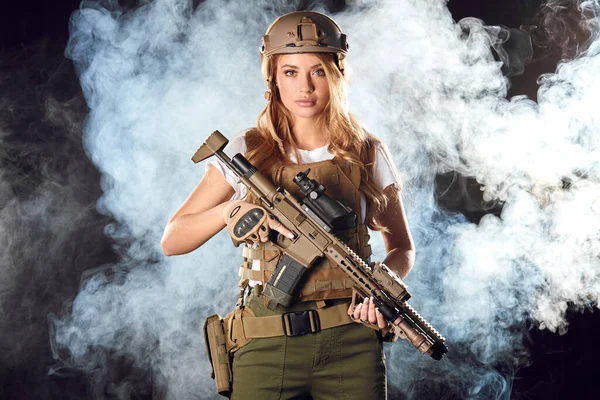 Mujer del ejército con arma sobre oscuridad humeante —  Fotos de Stock