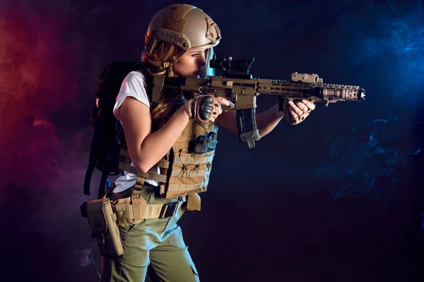 Soldado fêmea altamente armado em capacete de batalha segurando rifle assalto — Fotografia de Stock
