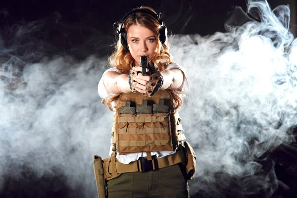 Frau in Schutzrüstung hält Waffe in der Hand. Armee, Engagement, Technologie. — Stockfoto