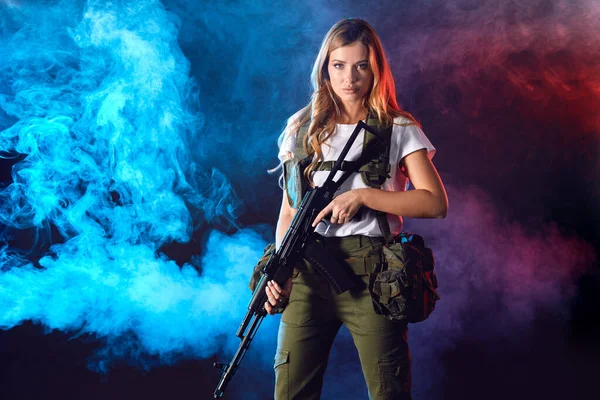 Junge blonde Scharfschützin im Militär-Outfit mit Sturmgewehr im Studio — Stockfoto