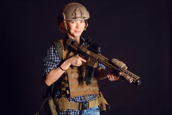 Mujer civil en uniforme táctico con rifle. Grabado en estudio sobre fondo negro —  Fotos de Stock