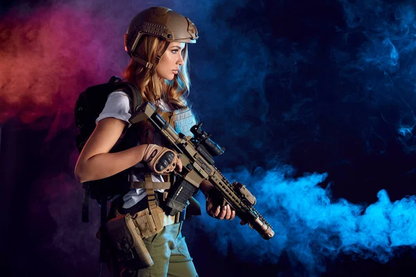 Woman soldier sniper in disguise with a sniper rifle and aims in smoky darkness — Stock Photo, Image