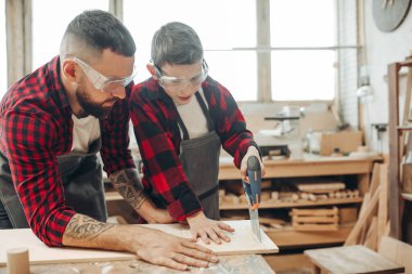 Babam ve oğlu atölyede çalışıyorlar. Tahta kesiyorlar. .