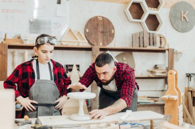 Cetvelli ve kalemli adamlar iş için tahta ölçüyorlar.