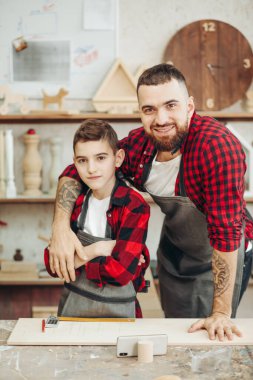 Baba ve oğul atölyede ahşap bir uçağın modelini tasarlıyorlar.