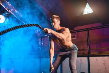 Halat dövüşü halatları olan bir adam spor salonunda idman yapıyor. Çapraz Uyum kavramı.