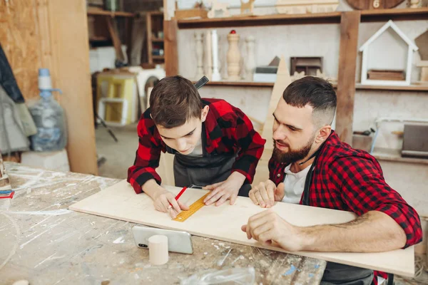 Dad and son in the workshop playing designing a model of a wooden plane — Stock Photo, Image