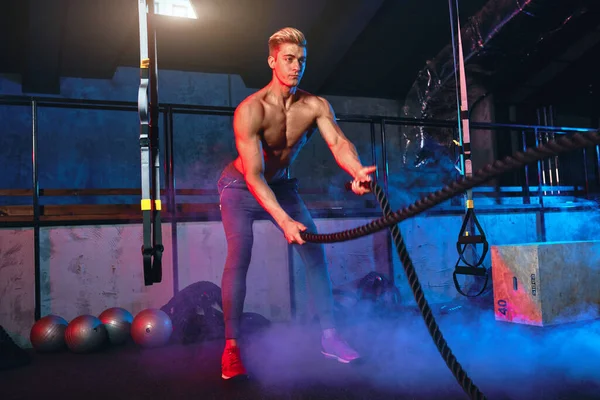 Muscular homem poderoso treinamento com corda no ginásio de treinamento funcional — Fotografia de Stock