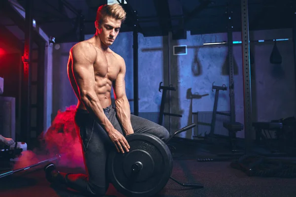 Erkek vücut geliştirme şampiyonu spor salonunda ağır halter levhası ile egzersiz yapıyor.. — Stok fotoğraf