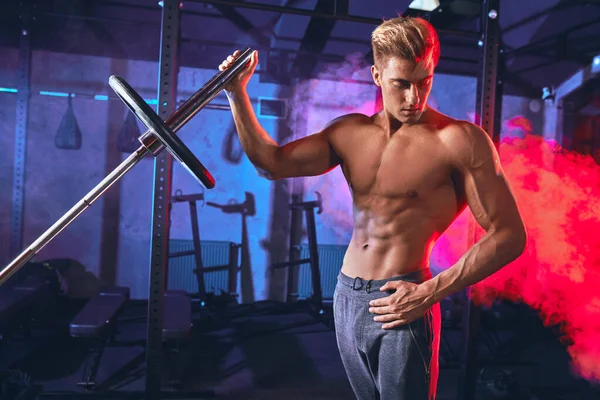 Fisiculturista muscular caucasiano flexionando placas de peso na barra de ferro no ginásio — Fotografia de Stock