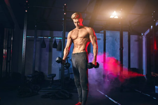 Shirtless homem branco começando o exercício com peso haltere no ginásio escuro — Fotografia de Stock