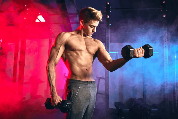 Treinador masculino com torso muscular segurando halteres em mãos no ginásio cross fit — Fotografia de Stock