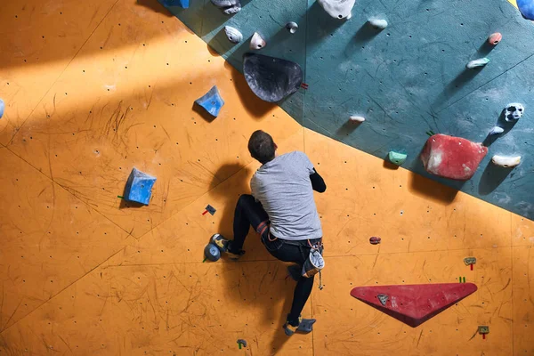 Homme étudiant escalade à mur artificiel, passer du temps libre dans la salle de gym de bloc — Photo