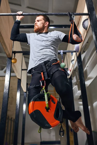 Спортивный спортсмен без предплечья делает упражнения для подтягивания со специальной нагрузкой — стоковое фото