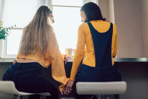 Twee aantrekkelijke mode meisjes houden elkaars handen en het delen van geheimen — Stockfoto