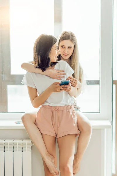 Duas irmãs tendo bate-papo online com amigos — Fotografia de Stock