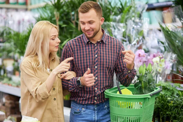 Schattig goed uitziende vrouw show op mooie plant in de markt — Stockfoto