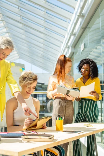 Impressionante intelligente bionda donna che punta un dito al notebook assistenti — Foto Stock