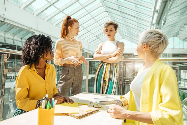 Három nő szidja a kollégáját. a nők meséljenek az új alkalmazottakról — Stock Fotó
