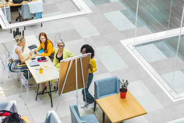 mixed race team working with whiteboard in office