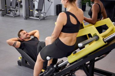 Formda kızlar sporcuya destek olurken o egzersizleri yapıyor.