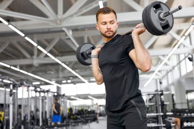 Atletik Kafkasyalı vücut geliştirici, kilo alıp kaslarını şişiriyor.