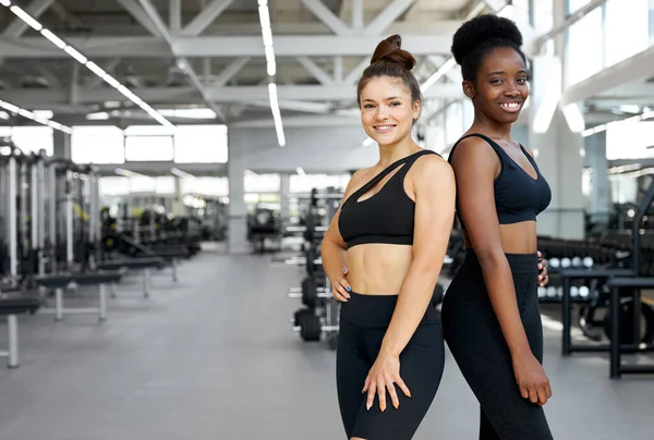 Portrait de deux filles sportives diverses en salle de gym — Photo