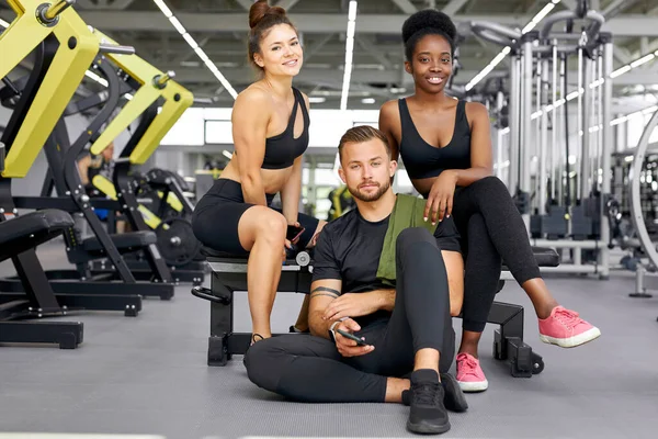 Deux filles en forme de formation avec entraîneur personnel dans la salle de gym — Photo