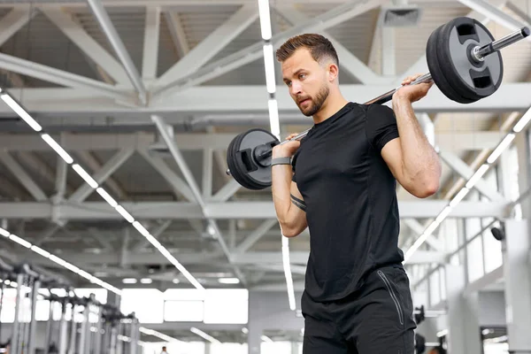 Caucasian athletic man pumping up muscles with barbells — Stock Photo, Image