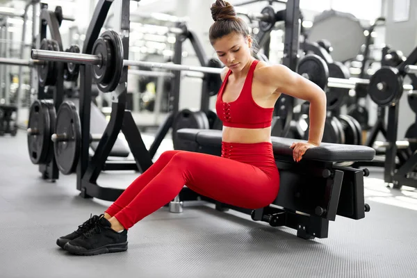 Zayıf atletik kız spor salonunda çömeliyor. — Stok fotoğraf