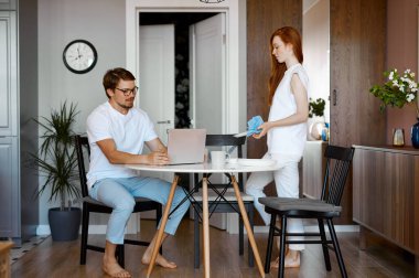 Güzel kızıl saçlı kadın ve çalışan adam evdeki mutfakta.