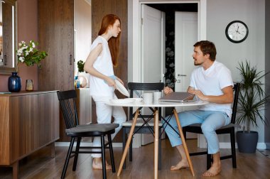 Çalışan adam ve kızıl saçlı kadın küfür ediyorlar.