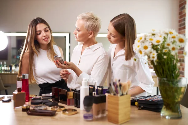 Make-up artist and girls pupils discuss cosmetics on master class — Stock Photo, Image