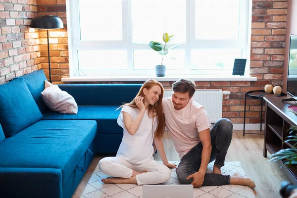 Junges Ehepaar ruht mit Laptop auf dem Fußboden — Stockfoto