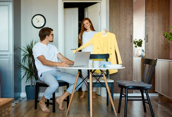 Attraktive Dame zeigt ihrem berufstätigen Mann neue Kleider — Stockfoto