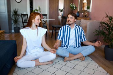 Kafkasyalı çift evde yoga yapıyor.