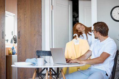 Kadın parti için kıyafet seçer, kocasından yardım ister.