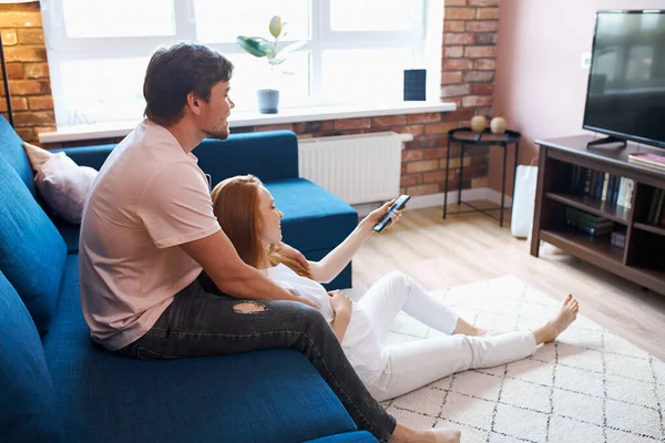 Zwanger vrouw kijken tv met man thuis — Stockfoto