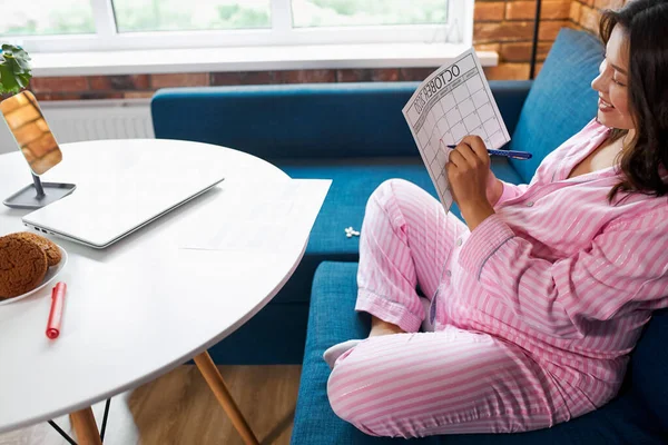 Jonge toekomstige moeder met kalender thuis en ongeduldig wachten op haar baby 's uitgerekend datum — Stockfoto